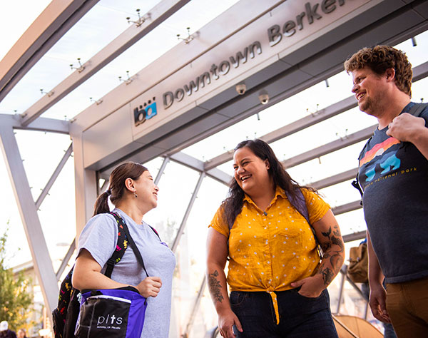 3 PLTS students stand under the Downtown Berkeley BART sign.